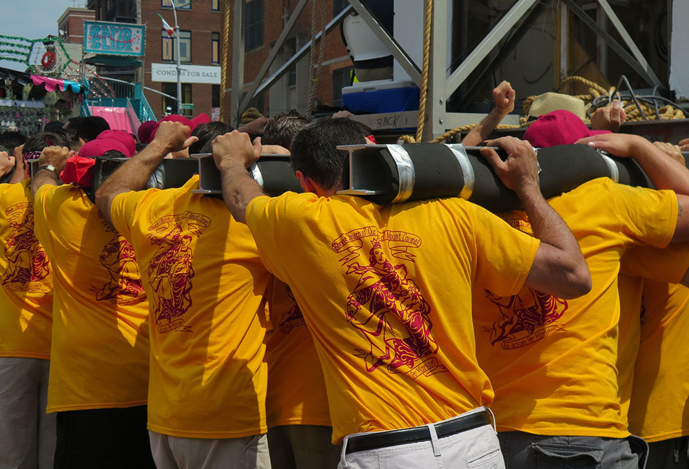 Men carry the 1-ton steel tower during the 2015 giglio parade in Williamsburg, Brooklyn, New York. (Dreamstime/Rebekah Burgess) Men carry the 1-ton steel tower during the 2015 giglio parade in Williamsburg, Brooklyn, New York. (Dreamstime/Rebekah Burgess)