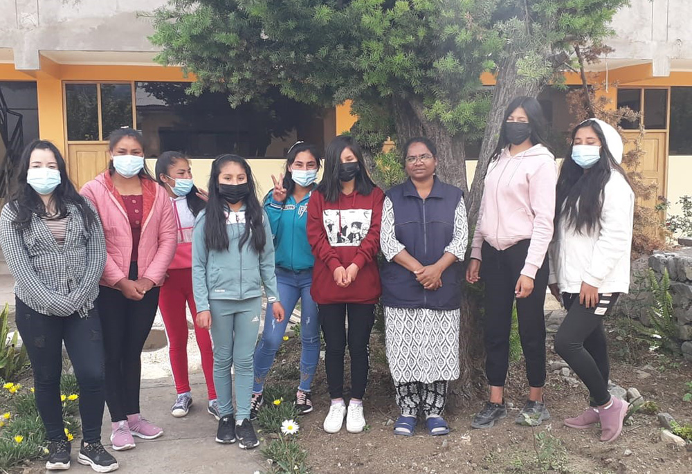 Sister Hilda, third from the right, stands with her students under an evergreen tree. The picture is taken outside Maria Reina, the sisters’ hostel, in the village of Curahuasi, Peru. (Courtesy of Hilda Mary Bernath)