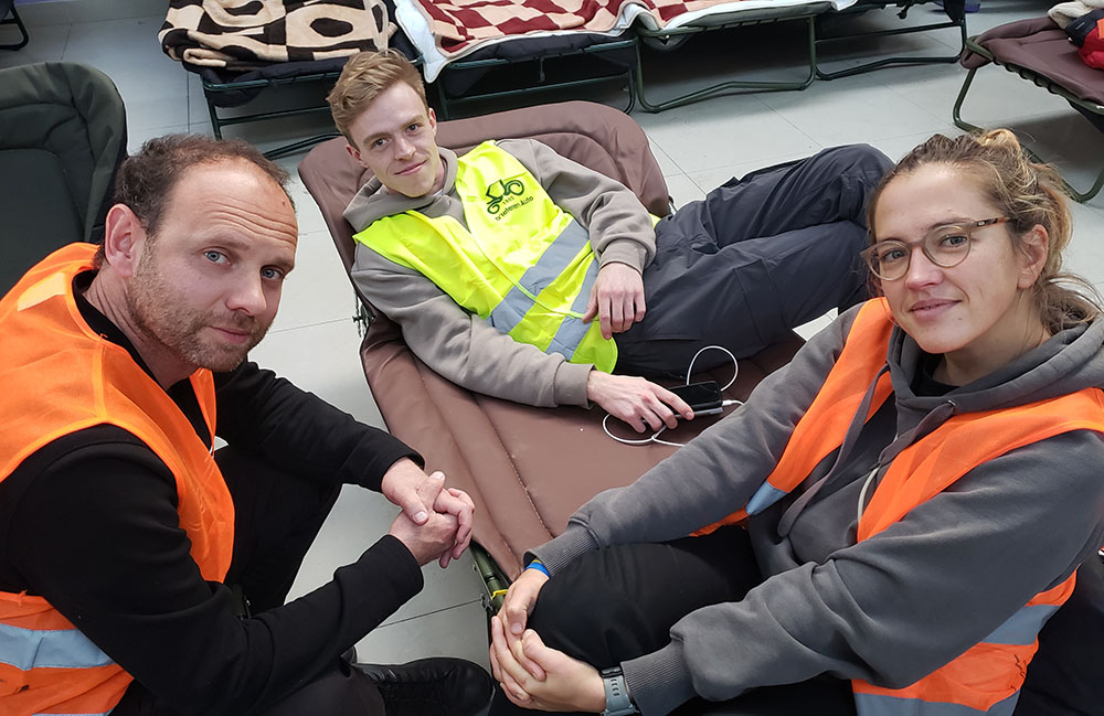 Ukrainian-American volunteer Lev Ivanov of Chicago, left, with fellow volunteers Anastasiya Vaynraukh, right, and Hannes Cools, center, from Belgium. (NCR photo/Chris Herlinger)