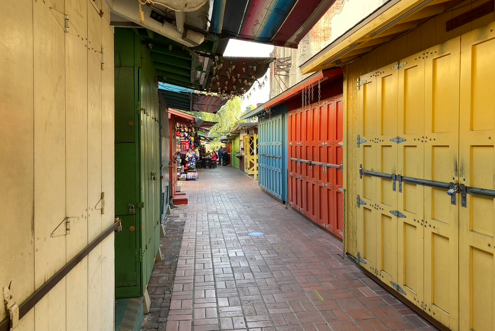 Shuttered shops on Olvera Street, Oct. 23. In the background, people sit outside a restaurant. (NCR photo/Lucy Grindon)