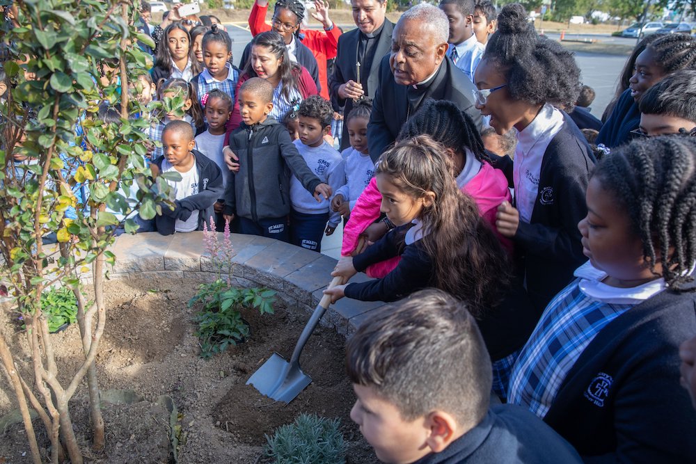 In this 2019 photo, then-Archbishop Wilton D. Gregory of Washington joins students at St. Mary's School in Landover Hills, Maryland, in planting a tree in celebration of the school's 65th anniversary. (CNS photo/Andrew Biraj, Catholic Standard)