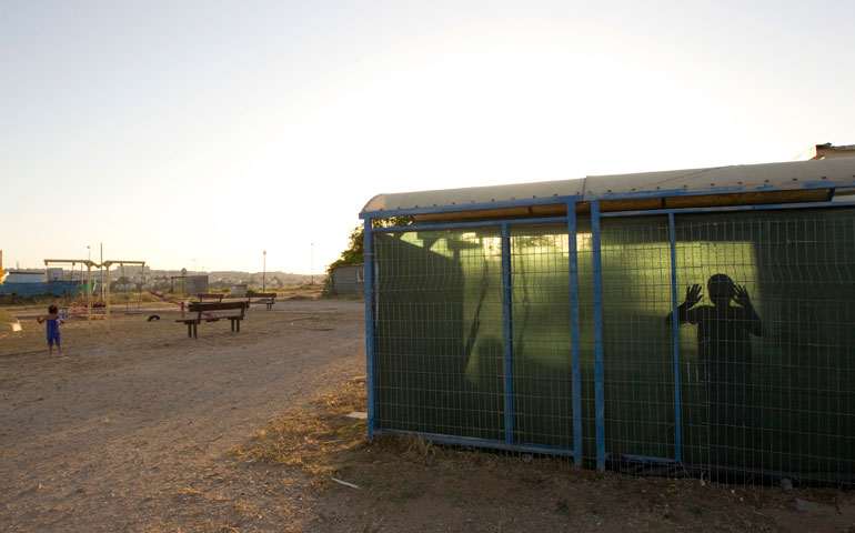 An Israeli boy looks out from his home in a settlement on Givat Hamatos May 17, 2012. (Newscom/Reuters/Ronen Zvulun)