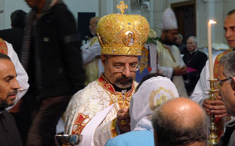 Coptic Catholic Patriarch Ibrahim Isaac Sedrak distributes Communion March 18 during the liturgy for his enthronement, or installation, at the Coptic Catholic Cathedral of the Blessed Virgin in Cairo. (CNS/James Martone)