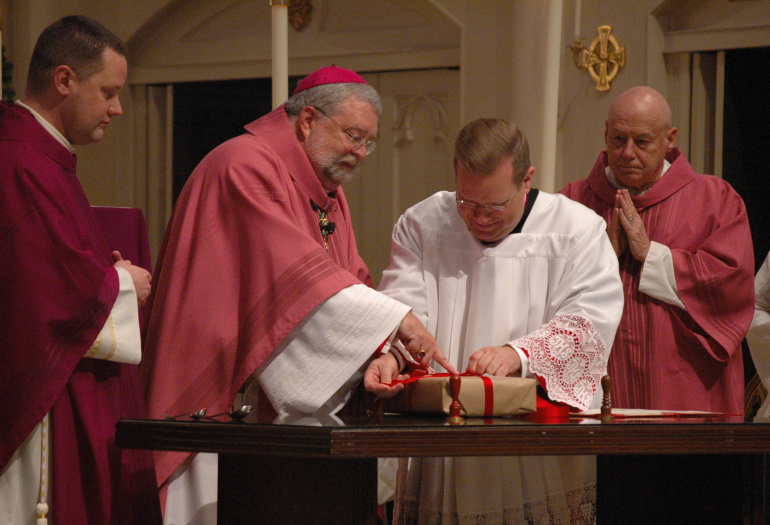 Bishop Daniel R. Jenky of Peoria, Ill., and Msgr. Stanley Deptula, executive director of the Archbishop Sheen Foundation, seal a box containing medical records and testimony regarding the alleged miraculous healing of James Fulton Engstrom during a Dec. 11, 2013 Mass at St. Mary's Cathedral in Peoria, Ill. (CNS/The Catholic Post/Tom Dermody)