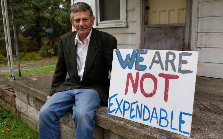 John Williams, a member of St. Stephen Parish in Niles, Ohio, is shown Oct. 16 with a sign he often carries to protest fracking throughout eastern Ohio. (CNS photo /Dennis Sadowski)