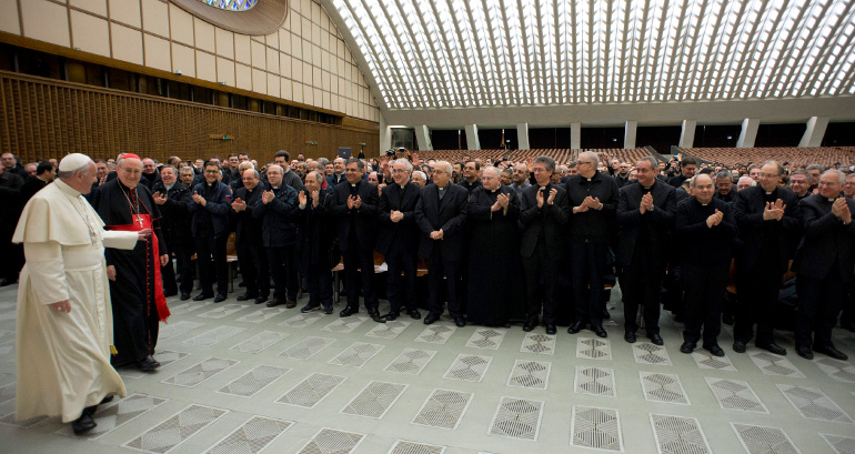 Pope Francis acknowledges applause from priests as he arrives for a meeting in the Paul VI audience hall at the Vatican March 6. (CNS/L'Osser vatore Romano)