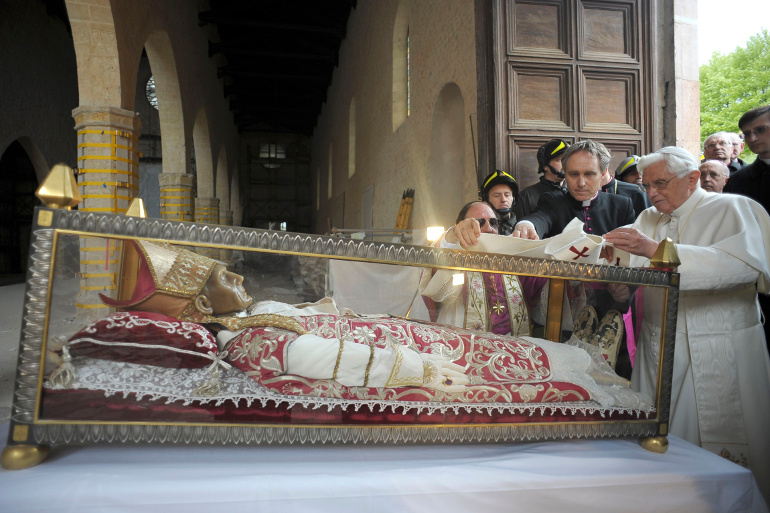 Pope Benedict XVI places a white stole on the remains of St. Celestine V, a 13th-century pope, during his 2009 visit to the earthquake-damaged Basilica of Santa Maria di Collemaggio in L'Aquila, Italy. St. Celestine was the last pope to voluntarily resig n before Pope Benedict stepped down in February 2013. (CNS/Reuters/L'Osservatore Romano)