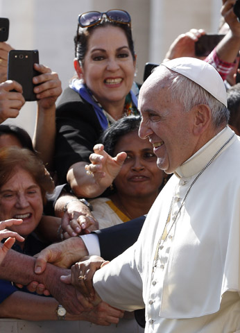 Pope Francis greets people as he arrives to lead his general audience in St. Peter's Square at the Vatican May 13. (CNS photo/Paul Haring)