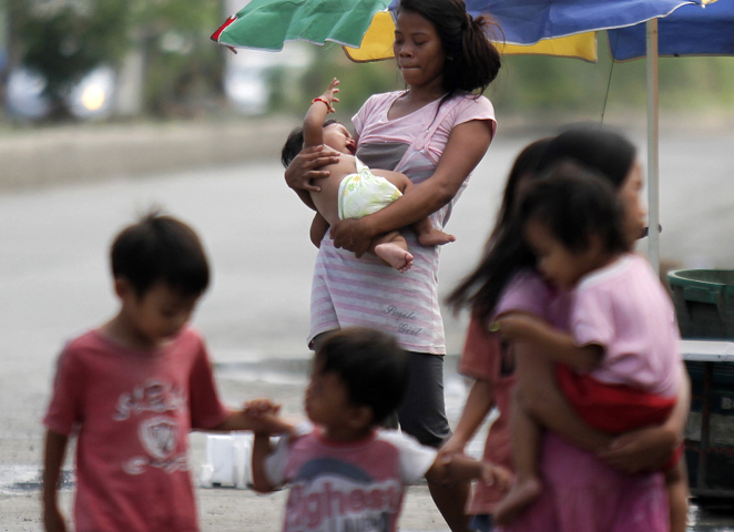 A mother walks with her children in a slum area in Cebu, Philippines, Aug. 30.(CNS/Jay Rommel Labra, EPA)