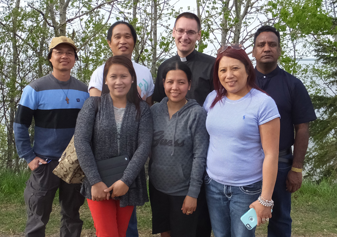 Catholics from St. John the Baptist Church who escaped the Fort McMurray wildfire in Alberta are pictured in Lac La Biche May 7. Back row from left are Leo Ganancial, Gary Agarin, Frs. Andrew Schoenberger and Prabhakar Kommareddy. Front row are Norie Sanchez, Shiela Ganancial and Cindy Julapton. (CNS/Glen Agran, Western Catholic Reporter)