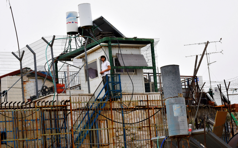 An Israeli settler stands beside fences surrounding an Israeli settlement located on the roof in the Arab section of the Old City of Jerusalem March 26, 2016. (CNS/Debbie Hill)