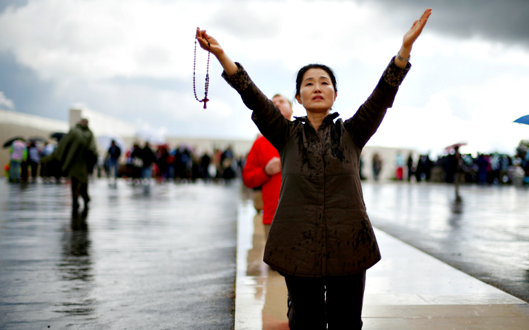 A pilgrim holding a rosary walks on her knees May 12, 2016, at the Marian shrine of Fatima in central Portugal. (CNS/Reuters/Rafael Marchante)