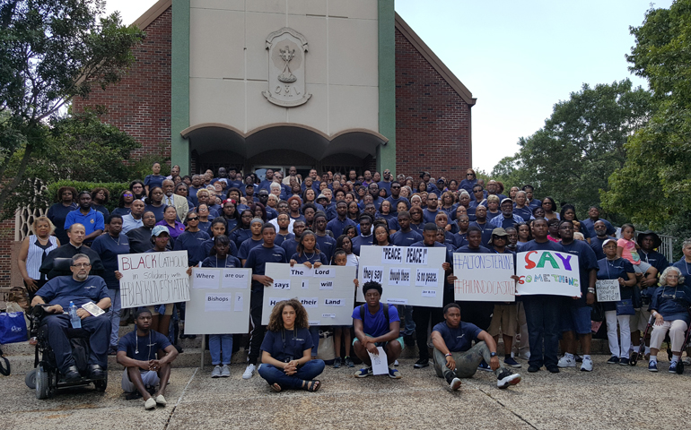 At the Archbishop Lyke Conference in San Antonio, attendees hold signs referencing recent police shootings of young black men and urging Catholic bishops to respond. (Kevin Winstead)