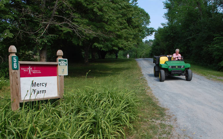 Mercy Sister Mary Quinn drives a farm vehicle at Mercy Farm in Benson, Vt., June 20. (CNS/Cori Fugere Urban, Vermont Catholic magazine)