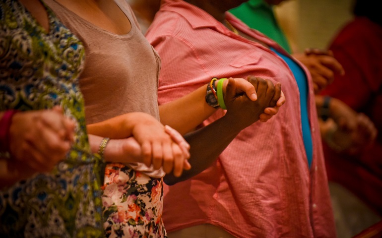 Congregants hold hands and pray for peace during Mass at All Saints Church in Milwaukee Aug. 18. (CNS/Catholic Herald/Juan C. Medina)