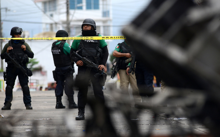 Police officers guard the municipal building in Catemaco, Mexico, Nov. 14 after it was set on fire following the disappearance of Fr. Jose Luis Sanchez Ruiz, pastor of Twelve Apostles parish. (CNS/Reuters/Oscar Martinez)