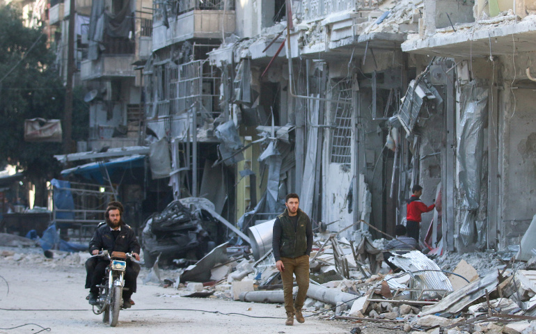 People are seen Nov. 17 in Aleppo, Syria, after an airstrike. Pope Francis has called events unfolding in the war-torn country a veritable "workshop of cruelty." (CNS / Abdalrhman Ismail, Reuters)