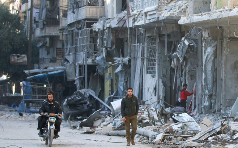 People are seen Nov. 17 in Aleppo, Syria, after an airstrike. (CNS/Abdalrhman Ismail, Reuters)