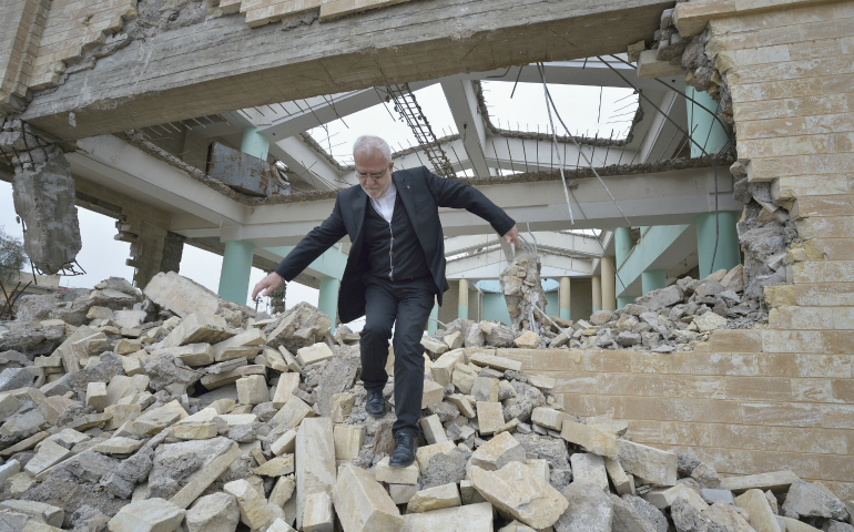 Father Emanuel Youkhana, an archimandrite of the Assyrian Church of the East, walks through the rubble of a demolished church in Mosul, Iraq, Jan. 27. (CNS photo/Paul Jeffrey)