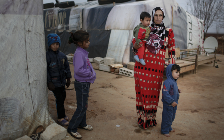 A mother stands with her children in 2014 in an informal tented settlement near Deir el Ahmar in the northern Bekaa Valley, Lebanon. (CNS photo/Sam Tarling, CRS)