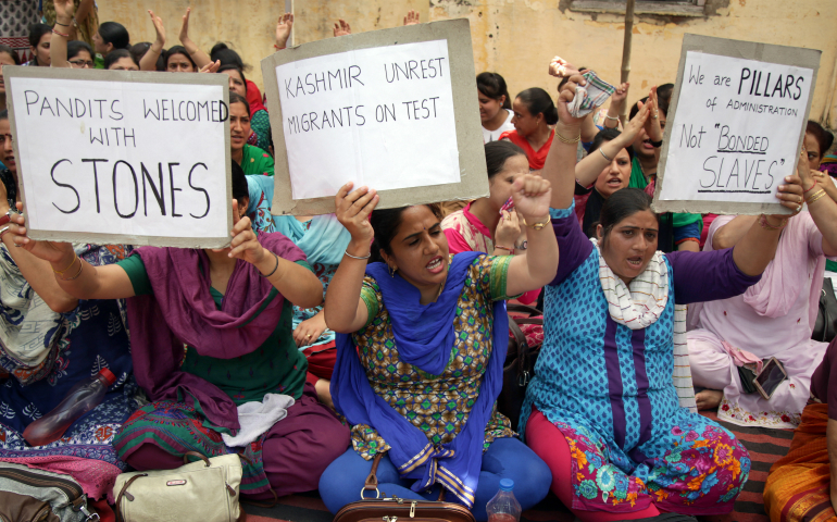 Kashmiri Pandit migrants hold placards and shout slogans as they protest in 2016 at the migrant relief commissioner office in Jammu, India. The Indian bishops' labor office has created an online system to register migrant workers, promote safe migration and help them in emergencies, reported ucanews.com. (CNS photo/Jaipal Singh, EPA)