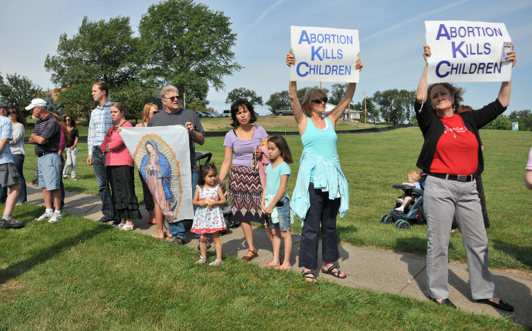 People hold pro-life signs in front of Planned Parenthood in Bettendorf, Iowa, in 2015. (CNS/Lindsay Steele, The Catholic Messenger)