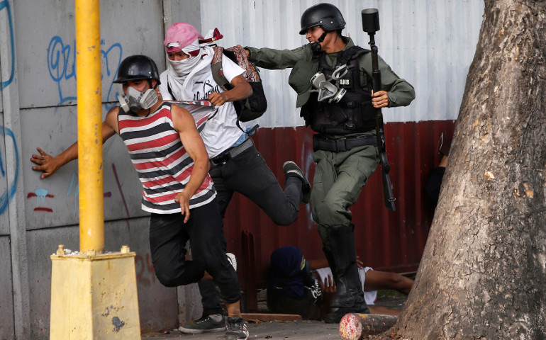 Demonstrators run away from riot security forces at a July 27 rally during a protest against Venezuelan President Nicolas Maduro's government in Caracas. (CNS/Andres Martinez Casares, Reuters)