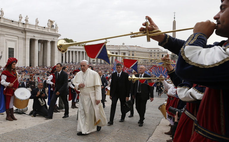 Pope Francis walks past an Italian musical group in traditional attire as he arrives to lead his general audience Wednesday in St. Peter's Square at the Vatican. (CNS/Paul Haring)