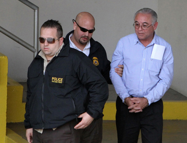 Agents with the FBI and the U.S. Immigration and Customs Enforcement arrest Fr. Israel Berrios on Tuesday in Guaynabo, Puerto Rico. (CNS/Reuters)