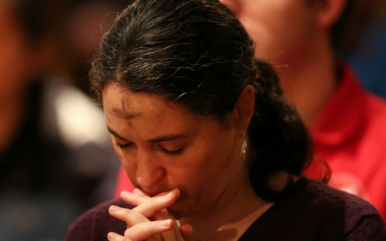 A woman prays during Ash Wednesday Mass March 1 in the Crypt Church at the Basilica of the National Shrine of the Immaculate Conception in Washington. (CNS photo/Bob Roller) 