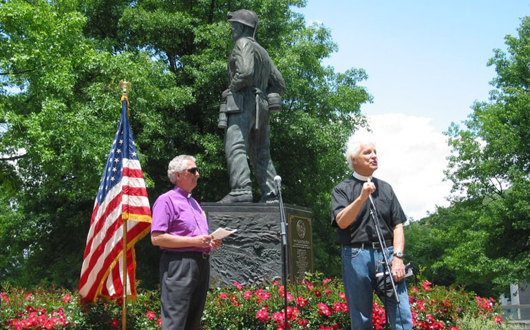 Lutheran Bishop Ralph Duncan, left, listens while the Rev. Jim Lewis, an Episcopal priest and member of Interfaith Worker Justice, speaks during a May 23 prayer service held in front of the West Virginia Coal Miner memorial statue in Charleston, W.Va.