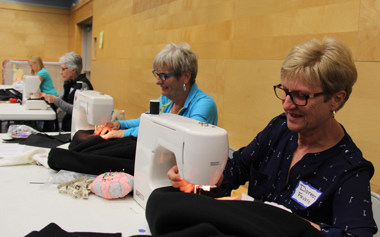 Members of Star of the Sea parish, White Rock, British Columbia, fabricate thick, waterproof coats for the homeless in the school gymnasium. (Agnieszka Krawczynski/The B.C. Catholic)