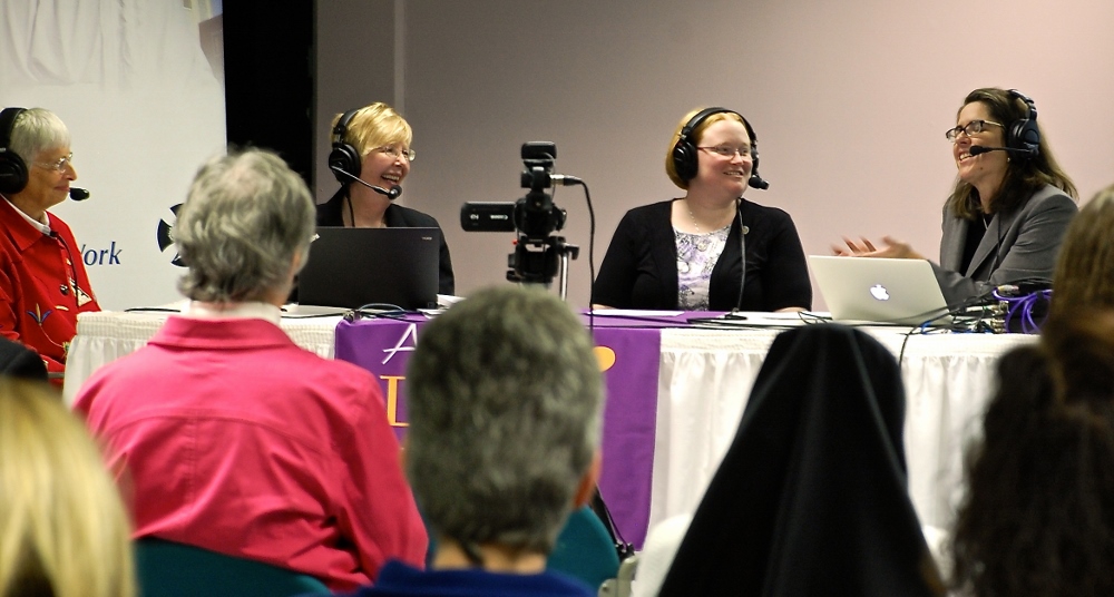 Four women in headsets at a table