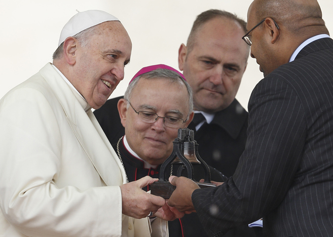 Pope Francis accepts a replica of the Liberty Bell from Philadelphia Mayor Michael Nutter as Philadelphia Archbishop Charles Chaput looks on Wednesday during the pope's general audience in St. Peter's Square at the Vatican. (CNS/Paul Haring)