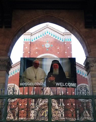 A poster displayed outside of a Catholic church in Istanbul welcomes Pope Francis, who will meet with Ecumenical Patriarch Bartholomew of Constantinople, right, on his trip to Turkey. (CNS/Nathalie Ritzmann)