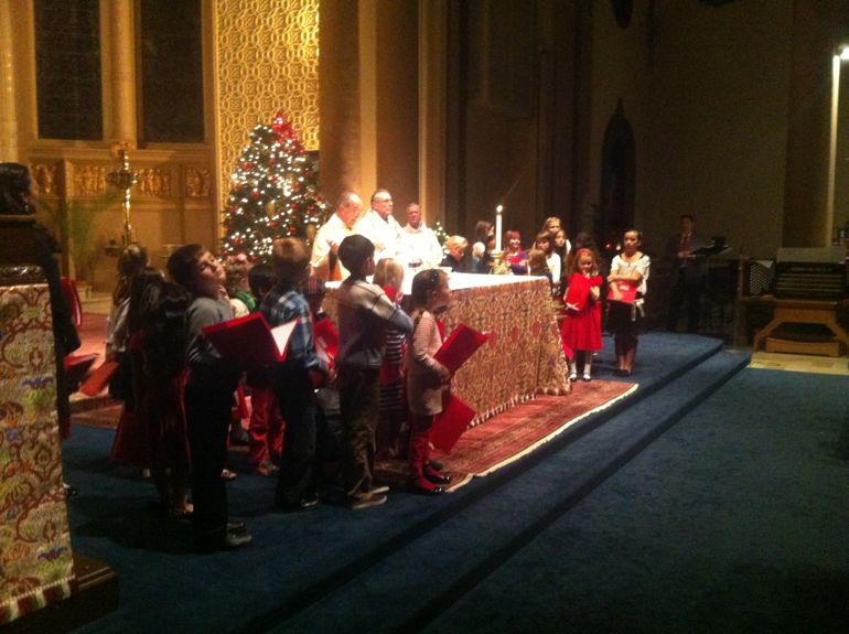 Jesuit pastor Ray Allender and Jesuit associate pastor Paul Bernadicou and children's choir