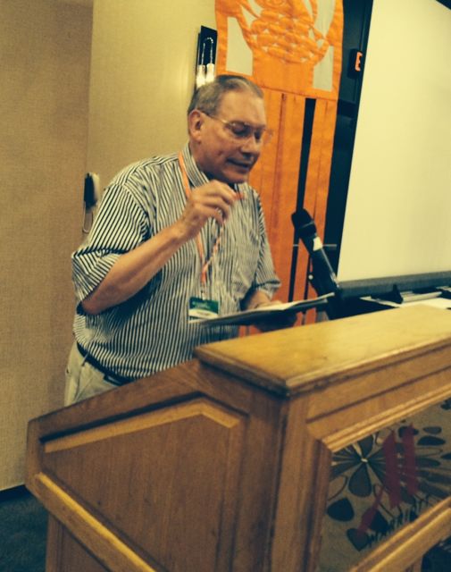 Fr. David Cooper, AUSCP board chair, announces resolution results (Photo by Tom Fox)