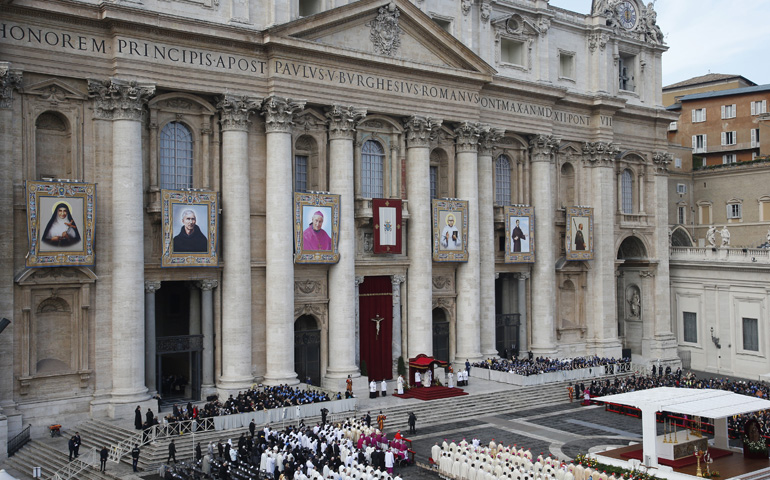 The banners of six Italian and Indian saints hang from the facade of St. Peter's Basilica as Pope Francis celebrates their canonization Mass on Sunday in St. Peter's Square at the Vatican. (CNS/Paul Haring)