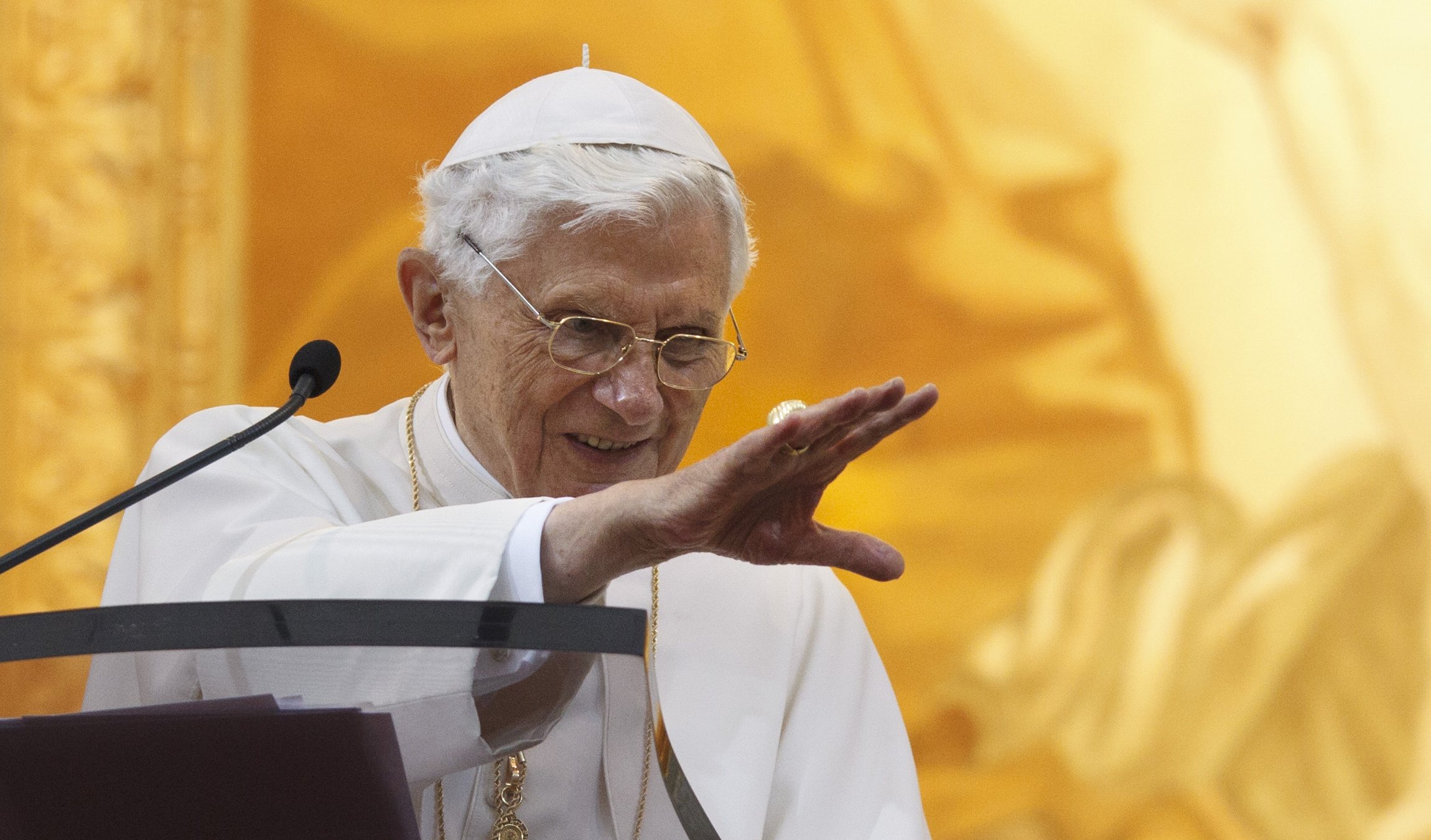 Pope Benedict XVI waves after praying the Angelus from a balcony overlooking the courtyard of the papal villa at Castel Gandolfo, Italy, on Sunday. (CNS/Paul Haring)