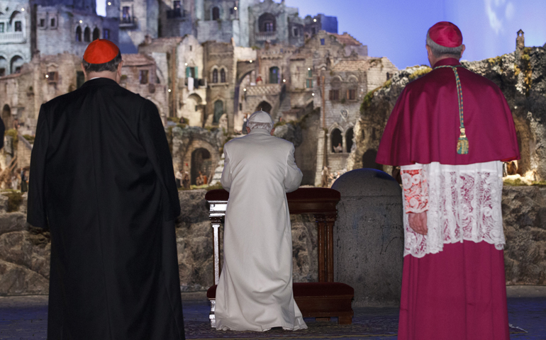 Pope Benedict XVI prays at the Nativity scene in St. Peter's Square after leading vespers in St. Peter's Basilica on New Year's Eve at the Vatican. (CNS/Paul Haring)
