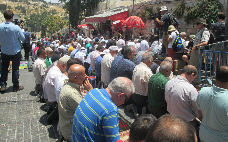 Muslim men pray just outside the Temple Mount by Lion’s Gate in protest, refusing to enter the Temple Mount until Israel removes the metal detectors it placed there following an attack last week. (RNS photo by Michele Chabin)