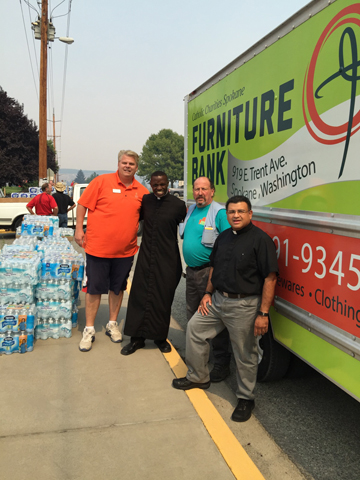 From left are Rob McCann, Executive Director of Catholic Charities Spokane; Father Luta Nsubuga, pastor of Our Lady of the Valley Parish in Okanogan; Tim Crabb, from Catholic Charities’ furniture bank warehouse; and Father Pedro Bautista-Peraza, pastor of the parishes in Brewster and Twisp. (Photo courtesy of Catholic Charities Spokane)