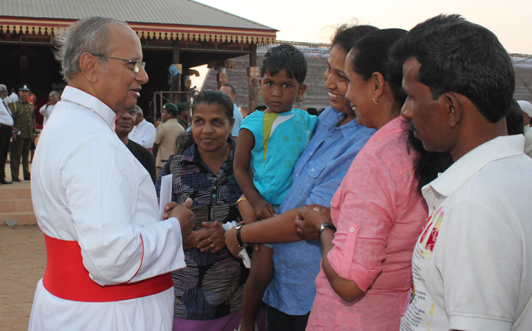 Cardinal Albert Malcolm Ranjith of Colombo, Sri Lanka, greets a family Sunday near the altar where Pope Francis will celebrate Mass on Wednesday. (CNS/Anto Akkara) 