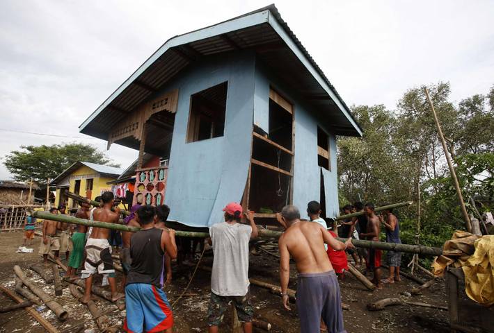 Residents lift a house damaged by Typhoon Rammasun, locally named Glenda, Thursday in a coastal village in Batangas, Philippines. (CNS/Reuters/Erik De Castro, Reuters)
