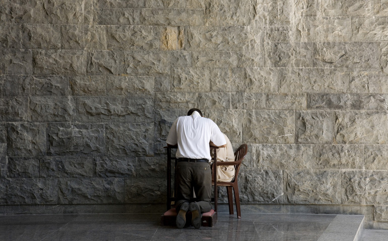 A man makes a confession to a priest prior to Sunday Mass at the Basilica of Our Lady of Lebanon in Harissa, east of Beirut, Aug. 26. (CNS/Dalia Khamissy)