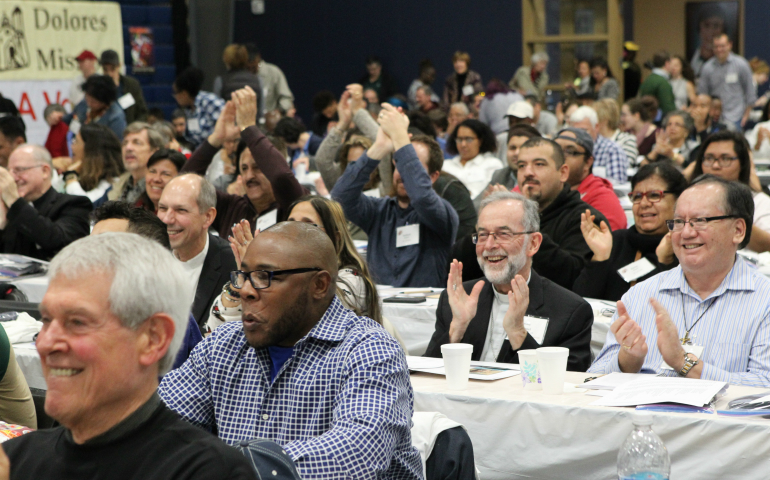 Attendees cheer a statement about justice for immigrants Feb. 16 during a the opening program of the U.S. regional World Meeting of Popular Movements in Modesto, Calif. (CNS photo/Dennis Sadowski)