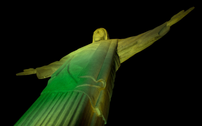 Rio's Christ the Redeemer Statue glows green to help kickoff the 2014 FIFA World Cup. (CNS/Daniel Coelho, RIOLUZ)