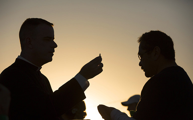 Msgr. J. Brian Bransfield gives Communion to a man attending Mass on the U.S. side of the border in El Paso, Texas, Feb. 17. (CNS/Nancy Wiechec) 