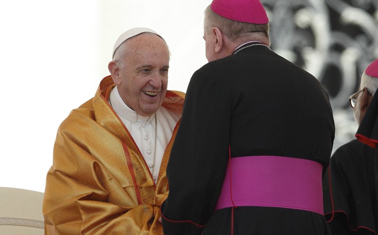 Pope Francis wears a garment presented by a prelate as he meets bishops during his general audience in St. Peter's Square at the Vatican May 31. (CNS photo/Paul Haring)