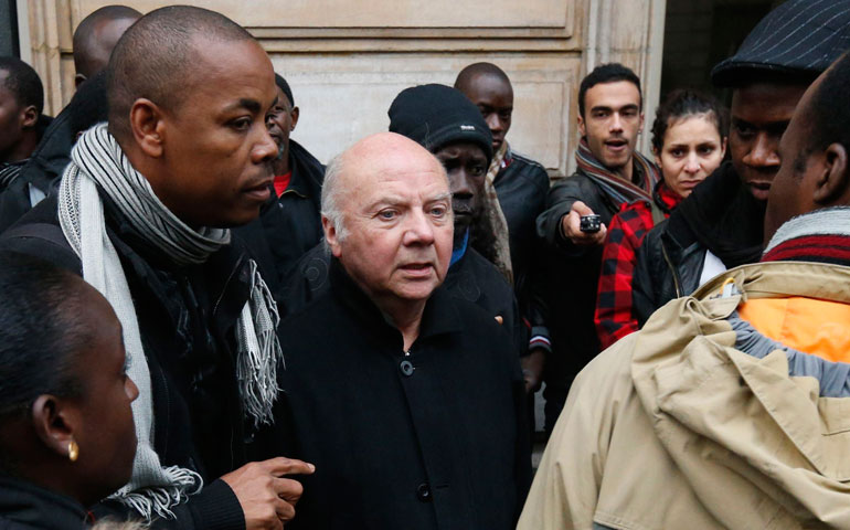 Bishop Jacques Gaillot speaks Jan. 3 with people in solidarity with hunger-striking illegal immigrant workers in Lille, France. (CNS/Reuters/Benoit Tessier)